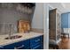 Stylish wet bar area with blue cabinetry, gray subway tile backsplash, and wine glass rack at 266 Hogans Valley Way, Cary, NC 27513