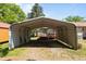 Metal carport shelters a wooden deck and a barbecue grill in backyard at 2719 S Nc 87, Graham, NC 27253