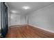 Spacious living room with hardwood floors, neutral gray walls, double doors, and stylish dark curtains at 2719 S Nc 87, Graham, NC 27253