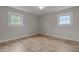Bright bedroom with wood-look floors, neutral paint, and dual windows at 305 W Old Rd, Lillington, NC 27546