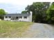 Side view of a lovely one-story brick home with black shutters, clean lines, and a gravel driveway at 3141 Wagoner Ln # 09, Graham, NC 27253