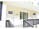Close up of the front porch with white brick, dark wood railing, and views of the house numbers at 3141 Wagoner Ln # 09, Graham, NC 27253