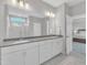 Bathroom with double vanity, white cabinets, and large mirror at 3313 Brunot St, New Hill, NC 27562