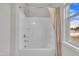 A bathroom with a tub/shower combo with a white shower curtain next to a window at 3313 Brunot St, New Hill, NC 27562