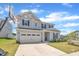 Two-story home featuring a light gray exterior, black shutters, and a two-car garage with a basketball hoop nearby at 3313 Brunot St, New Hill, NC 27562