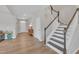 Inviting foyer featuring hardwood floors, neutral walls, a staircase, and a decorative wood-finished console table at 3313 Brunot St, New Hill, NC 27562