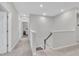 Hallway with gray walls, plush carpet, and access to the laundry room and staircase at 3313 Brunot St, New Hill, NC 27562