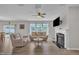 Bright living room featuring hardwood floors, neutral walls, a fireplace, and ample natural light from the large windows at 3313 Brunot St, New Hill, NC 27562
