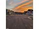 Tranquil street view featuring a tree-lined road, sidewalks, and beautiful homes under a fiery sunset sky at 3313 Brunot St, New Hill, NC 27562