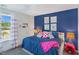 Bright bedroom featuring a blue accent wall, stylish decor, and a window with views of the outside at 366 Bunker Hill Place, Angier, NC 27501