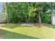 Backyard features lush lawn with trees and a concrete slab perfect for outdoor gatherings at 3713 Phillips W Way, Durham, NC 27713