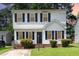 Charming two-story home features black shutters, a front yard with grass, and manicured bushes at 3713 Phillips W Way, Durham, NC 27713