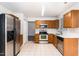 Kitchen with stainless steel appliances, oak cabinets, and tile flooring, offering a practical cooking space at 3713 Phillips W Way, Durham, NC 27713