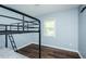 Cozy bedroom featuring a bunk bed, wood flooring, and a window at 3714 Mt Zion Church Rd, Mebane, NC 27302