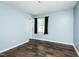 Cozy bedroom with blue walls and a window with black curtains, and a modern dark wood floor at 3714 Mt Zion Church Rd, Mebane, NC 27302