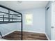 Cozy bedroom featuring a bunk bed, wood flooring, and a window at 3714 Mt Zion Church Rd, Mebane, NC 27302