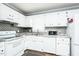 Bright kitchen features white cabinets, appliances, and subway tile backsplash paired with wood floors at 3714 Mt Zion Church Rd, Mebane, NC 27302