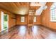Spacious living room featuring wood walls, large windows, hardwood floor and a staircase to a second level at 3714 Mt Zion Church Rd, Mebane, NC 27302