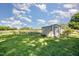 Spacious backyard featuring a metal shed with a rolling door perfect for storage in a well-maintained green lawn at 40 Crepe Myrtle Ct, Angier, NC 27501