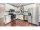 This kitchen features white cabinets, granite countertops, stainless appliances, hardwood floors, and tiled backsplash at 40 Crepe Myrtle Ct, Angier, NC 27501