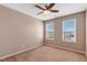 Well-lit bedroom with neutral carpet, ceiling fan, and two large windows at 4109 Massey Preserve Trl, Raleigh, NC 27616