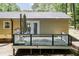 A wooden back deck features an umbrella and access to the home via double glass doors at 4221 River Run Dr, Sanford, NC 27332