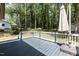 A spacious wooden back deck has an umbrella and faces a wooded area at 4221 River Run Dr, Sanford, NC 27332