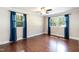 A bedroom with hardwood floors, dual windows with blue curtains, crown molding and a ceiling fan at 4221 River Run Dr, Sanford, NC 27332
