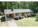 A ranch-style house with mature landscaping and a metal roof is surrounded by trees at 4221 River Run Dr, Sanford, NC 27332
