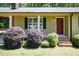 Close-up of the home's front entrance, featuring a classic red door and charming landscaping at 4221 River Run Dr, Sanford, NC 27332