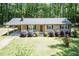 Charming single-story home with a metal roof, cozy front porch, and well-manicured landscaping in a wooded setting at 4221 River Run Dr, Sanford, NC 27332