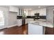 Bright eat-in kitchen boasts white cabinets, stainless steel appliances, and granite countertops with black backsplash at 4221 River Run Dr, Sanford, NC 27332