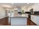 Updated kitchen with white cabinetry, island seating, granite countertops, and stainless steel appliances at 4221 River Run Dr, Sanford, NC 27332