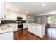 Open kitchen features stainless steel appliances, white cabinets, granite countertops, and a kitchen island at 4221 River Run Dr, Sanford, NC 27332