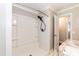 A tile shower with a detachable shower head and built in shelving and an adjacent vanity and doorway at 4221 River Run Dr, Sanford, NC 27332