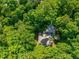 An aerial view of a home surrounded by dense trees, showcasing its secluded setting and privacy at 445 Ridge Springs Dr, Chapel Hill, NC 27516