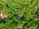 An aerial view of a home surrounded by dense trees in a neighborhood setting at 445 Ridge Springs Dr, Chapel Hill, NC 27516