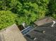 The roof of the house is visible with skylights and a deck and a heavy coverage of trees surround the house at 445 Ridge Springs Dr, Chapel Hill, NC 27516