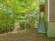 Wooded backyard with patio and stairs to deck at 445 Ridge Springs Dr, Chapel Hill, NC 27516