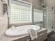 Relaxing bathroom with a jacuzzi tub, glass block window, and separate shower at 445 Ridge Springs Dr, Chapel Hill, NC 27516