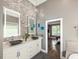 Bright bathroom featuring a double vanity, backlit mirrors, and gray accent wall at 445 Ridge Springs Dr, Chapel Hill, NC 27516