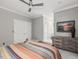 Spacious bedroom with soft, neutral colors, ceiling fan, art, and dresser at 445 Ridge Springs Dr, Chapel Hill, NC 27516