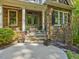 Inviting entryway with stone accents, manicured landscaping, and a cozy front porch at 445 Ridge Springs Dr, Chapel Hill, NC 27516