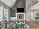 Comfortable living room featuring stone fireplace, built-in shelves, and plenty of natural light at 445 Ridge Springs Dr, Chapel Hill, NC 27516