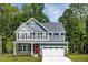 Charming two-story home featuring a red door, gray siding, and lush landscaping at 488 Freedom Trail Dr, Angier, NC 27592