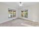 Bright bedroom with neutral walls, carpet, two windows and a ceiling fan at 50 Tyler Ct, Henderson, NC 27537