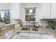 Bright kitchen with granite countertops, stainless steel sink, and white cabinetry at 50 Tyler Ct, Henderson, NC 27537