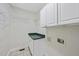 Spacious laundry room featuring utility sink, storage cabinets and wire shelving at 50 Tyler Ct, Henderson, NC 27537