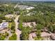 Aerial view shows townhome community surrounded by trees, highway, and buildings at 509 Darby Glen Ln, Durham, NC 27713