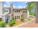 Rear exterior of tan townhome with windows, patio, siding, and greenery at 509 Darby Glen Ln, Durham, NC 27713